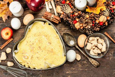 Elma Charlotte pişirmeye hazır. Mutfak gereçleri, malzemeler seti, mevsimlik dekorasyon. Baharatlı tatlı hamur işleri pişiriyorum. Eski ahşap zemin, üst manzara