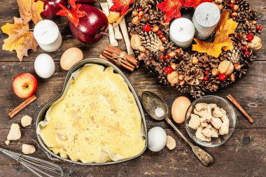 Elma Charlotte pişirmeye hazır. Mutfak gereçleri, malzemeler seti, mevsimlik dekorasyon. Baharatlı tatlı hamur işleri pişiriyorum. Eski ahşap zemin, üst manzara