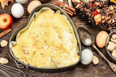 Elma Charlotte pişirmeye hazır. Mutfak gereçleri, malzemeler seti, mevsimlik dekorasyon. Baharatlı tatlı hamur işleri pişiriyorum. Eski ahşap zemin, üst manzara