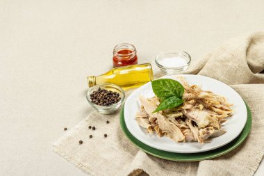 Yeşillik ve baharatlı haşlanmış tavuk eti. Düşük yağlı hayvan proteini, sağlıklı besin yaşam tarzı. Çatal bıçak takımı, beton zeminde doğal yağ, kopyalama alanı