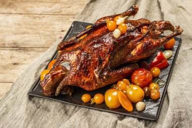 Elmayla doldurulmuş fırında ördek. Kümes hayvanları sebze turşusuyla servis edilir. Noel, Şükran Günü ya da herhangi bir bayram için şenlikli bir yemek. Ahşap zemin, çatal bıçak takımı, kapatın.