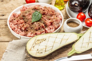 Patlıcan, et, sebze ve baharatla pişirilmeye hazır. Ahşap arka plan, mutfak gereçleri, kırsal stil, kapat