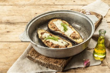 Doldurulmuş patlıcan, et, sebze ve baharatla birlikte yenmeye hazır. Ahşap zemin, mutfak gereçleri, köy tarzı, kopyalama alanı