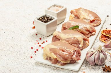Kemiksiz ve derisiz çiğ tavuk budu. Sağlıklı yemek, baharat ve sarımsak hazırlamak için kullanışlı bir malzeme. Hafif macun arkaplanı, kopyalama alanı
