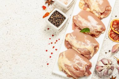 Kemiksiz ve derisiz çiğ tavuk budu. Sağlıklı yemek, baharat ve sarımsak hazırlamak için kullanışlı bir malzeme. Hafif macun arkaplanı, üst görünüm