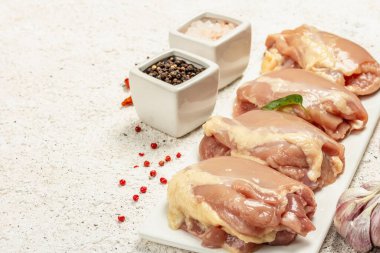 Kemiksiz ve derisiz çiğ tavuk budu. Sağlıklı yemek, baharat ve sarımsak hazırlamak için kullanışlı bir malzeme. Hafif macun arkaplanı, kopyalama alanı