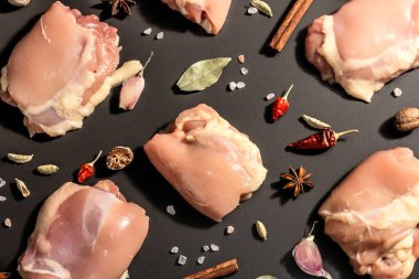 Kemiksiz ve derisiz çiğ tavuk butları. Sağlıklı yemek, baharat ve sarımsak hazırlamak için kullanışlı bir malzeme. Siyah taş arka plan, modaya uygun sert ışık, karanlık gölge, üst görüş