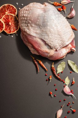 Baharatlı çiğ hindi eti. Sağlıklı yemek, baharat ve sarımsak hazırlamak için kullanışlı bir malzeme. Modern sert ışık, karanlık gölge, siyah taş arkaplan, üst görünüm