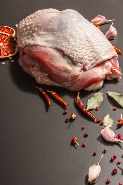 Baharatlı çiğ hindi eti. Sağlıklı yemek, baharat ve sarımsak hazırlamak için kullanışlı bir malzeme. Modern sert ışık, karanlık gölge, siyah taş zemin, kopyalama alanı