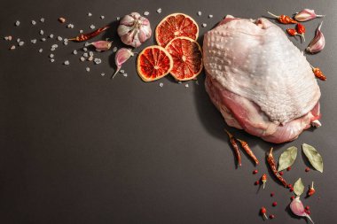 Baharatlı çiğ hindi eti. Sağlıklı yemek, baharat ve sarımsak hazırlamak için kullanışlı bir malzeme. Modern sert ışık, karanlık gölge, siyah taş arkaplan, üst görünüm