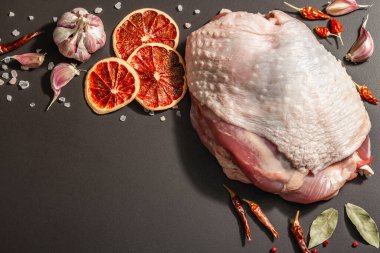 Baharatlı çiğ hindi eti. Sağlıklı yemek, baharat ve sarımsak hazırlamak için kullanışlı bir malzeme. Modern sert ışık, karanlık gölge, siyah taş arkaplan, üst görünüm