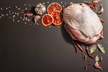 Baharatlı çiğ hindi eti. Sağlıklı yemek, baharat ve sarımsak hazırlamak için kullanışlı bir malzeme. Modern sert ışık, karanlık gölge, siyah taş arkaplan, üst görünüm