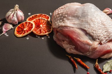 Baharatlı çiğ hindi eti. Sağlıklı yemek, baharat ve sarımsak hazırlamak için kullanışlı bir malzeme. Modern sert ışık, karanlık gölge, siyah taş zemin, kopyalama alanı