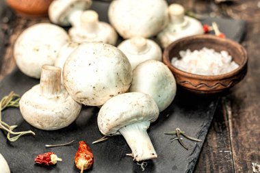 Baharatlı ve otlu taze şampiyonlar. Vejetaryen yemeği pişirmek için ham malzeme. Eski ahşap arka plan, modaya uygun aydınlık, karanlık gölge, kırsal tarz, yakın çekim.