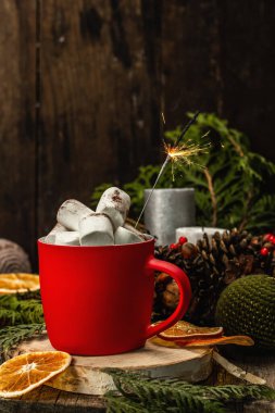 Hot cocoa or chocolate with marshmallows and sparklers. Christmas traditional decor, New Year festive arrangement. The concept of coziness, wooden background