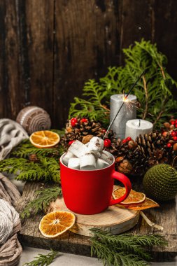 Hot cocoa or chocolate with marshmallows and sparklers. Christmas traditional decor, New Year festive arrangement. The concept of coziness, wooden background