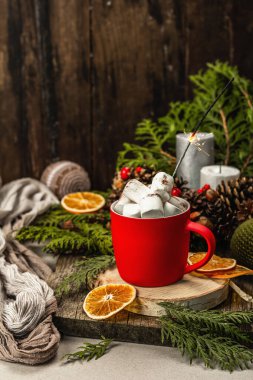 Hot cocoa or chocolate with marshmallows and sparklers. Christmas traditional decor, New Year festive arrangement. The concept of coziness, wooden background