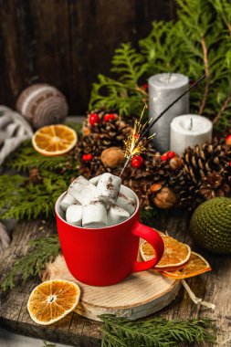 Hot cocoa or chocolate with marshmallows and sparklers. Christmas traditional decor, New Year festive arrangement. The concept of coziness, wooden background