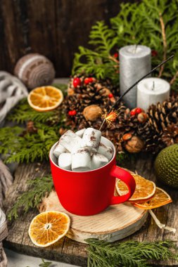 Hot cocoa or chocolate with marshmallows and sparklers. Christmas traditional decor, New Year festive arrangement. The concept of coziness, wooden background