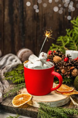 Hot cocoa or chocolate with marshmallows and sparklers. Christmas traditional decor, New Year festive arrangement. The concept of coziness, wooden background