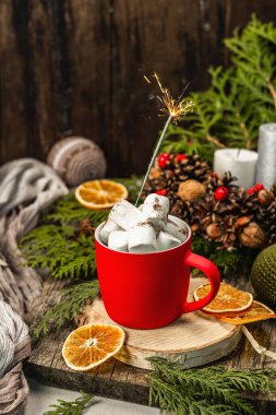 Hot cocoa or chocolate with marshmallows and sparklers. Christmas traditional decor, New Year festive arrangement. The concept of coziness, wooden background
