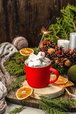 Hot cocoa or chocolate with marshmallows and sparklers. Christmas traditional decor, New Year festive arrangement. The concept of coziness, wooden background