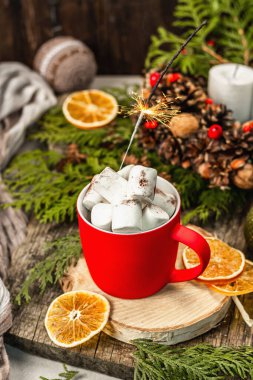 Hot cocoa or chocolate with marshmallows and sparklers. Christmas traditional decor, New Year festive arrangement. The concept of coziness, wooden background