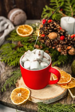 Hot cocoa or chocolate with marshmallows and sparklers. Christmas traditional decor, New Year festive arrangement. The concept of coziness, wooden background
