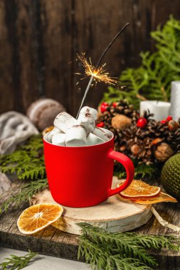 Hot cocoa or chocolate with marshmallows and sparklers. Christmas traditional decor, New Year festive arrangement. The concept of coziness, wooden background