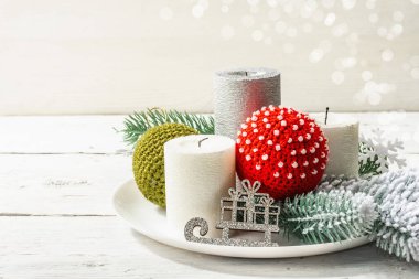 Christmas composition for the table with candles, New Year crocheted toys, fir tree branches. White wooden background, close up