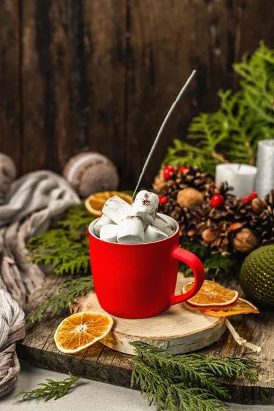 Hot cocoa or chocolate with marshmallows and sparklers. Christmas traditional decor, New Year festive arrangement. The concept of coziness, wooden background