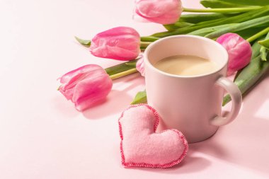 Romantik düz kompozisyon, bir fincan kahve, yumuşak keçeli kalpler ve taze laleler. Sevgililer günü ya da anneler günü, düğün, günaydın konsepti. Beyaz tahta arkaplan, boşluğu kopyala