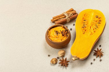 Çiğ balkabağının yarısı tereyağlı püre ve baharatlı. Yemek pişirmek için çeşitli malzemeler, taş beton zemin, kopyalama alanı