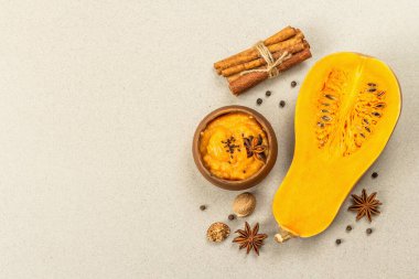 Çiğ balkabağının yarısı tereyağlı püre ve baharatlı. Yemek pişirmek için çeşitli malzemeler, taş beton arka plan, üst görünüm