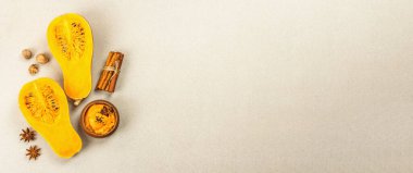 Çiğ balkabağının yarısı tereyağlı püre ve baharatlı. Yemek pişirmek için çeşitli malzemeler, taş beton arka plan, afiş