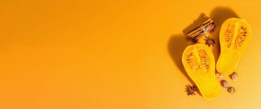 Baharatlı tereyağlı balkabağı. Geleneksel sonbahar aşçılık malzemeleri, turuncu arkaplan, sert ışık, koyu gölge, pankart biçimi