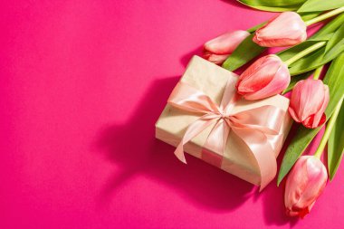 Kutlama konsepti çiçek kompozisyonu, bir buket pembe lale ve bir hediye. Uluslararası Kadınlar, Sevgililer Günü, ya da Anneler Günü, Düğün. Magenta arkaplanı, düz yatay