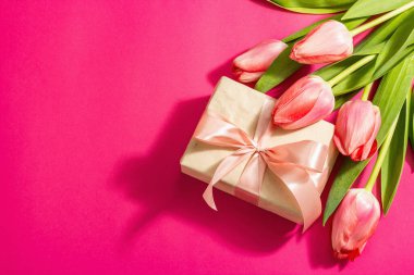 Kutlama konsepti çiçek kompozisyonu, bir buket pembe lale ve bir hediye. Uluslararası Kadınlar, Sevgililer Günü, ya da Anneler Günü, Düğün. Magenta arkaplanı, düz yatay