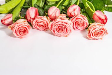Beyaz arka planda izole edilmiş taze gül buketi ve laleler. Romantik hediye konsepti, pembe çiçekler. Anneler, Sevgililer Günü ya da Kadınlar Günü. Model, şablon, tebrik kartı, düz uzanma