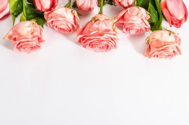 Beyaz arka planda izole edilmiş taze gül buketi ve laleler. Romantik hediye konsepti, pembe çiçekler. Anneler, Sevgililer Günü ya da Kadınlar Günü. Model, şablon, tebrik kartı, düz yatak, üst görünüm