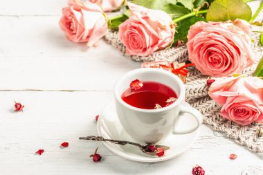Romantik çay kavramı. Paketlenmiş hediye, amber çayı, bir buket narin gül, şeker, şenlikli dekor. Sevgililer Günü konsepti, Kadınlar Günü 8 Mart, Düğün. Beyaz pano arkaplanı, kopyala