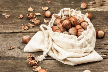 Kabuklu, olgun fındıklar. Çamaşır torbasında hasat, atıştırmalıklar için sağlıklı bir malzeme. Eski ahşap arka plan, kapat