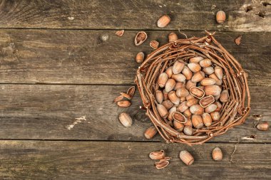 Kabuklu, olgun fındıklar. Hasır sepette hasat et, atıştırmalıklar için sağlıklı bir malzeme. Eski ahşap zemin, üst manzara
