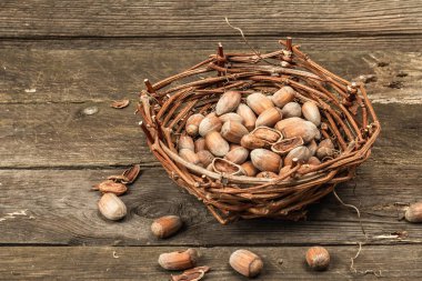 Kabuklu, olgun fındıklar. Hasır sepette hasat et, atıştırmalıklar için sağlıklı bir malzeme. Eski tahta arkaplan, kopyalama alanı