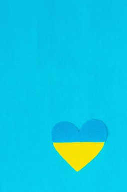 Ukrayna bayrağı renginde bir kalp. Savaş konseptini durdurun. Mavi arka plandaki kalp. Düz yatak, metin, model, şablon, üst görünüm için bir yer