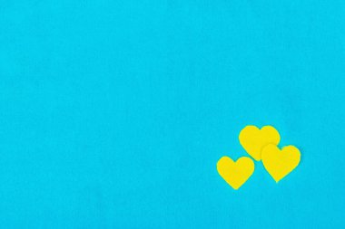 Ukrayna bayrağı renginde bir kalp. Savaş konseptini durdurun. Mavi arka plandaki kalp. Düz yatak, metin, model, şablon, üst görünüm için bir yer