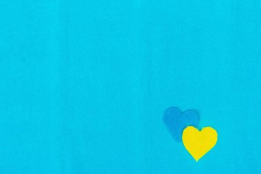 Ukrayna bayrağı renginde bir kalp. Savaş konseptini durdurun. Mavi arka plandaki kalp. Düz yatak, metin, model, şablon, üst görünüm için bir yer