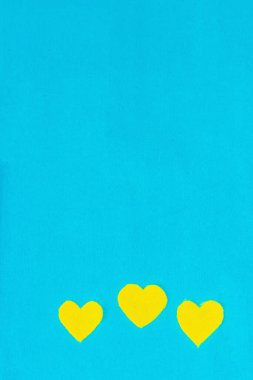 Ukrayna bayrağı renginde bir kalp. Savaş konseptini durdurun. Mavi arka plandaki kalp. Düz yatak, metin, model, şablon, üst görünüm için bir yer