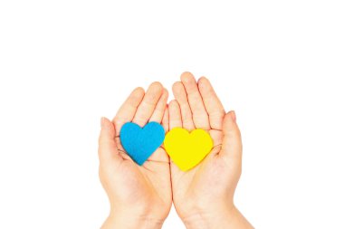 Çocuk avuçlarında Ukrayna bayrağı renginde kalpler var. Savaş konseptini durdurun. Beyaz arka planda izole edilmiş bir kalp hissettim. Düz yatak, metin, model, şablon, üst görünüm için bir yer