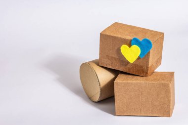 Ukrayna 'ya savaşta yardım etme kavramı. Beyaz arka planda izole edilmiş Ukrayna bayrağı renginde kalpleri olan kutular. Modern sert ışık, karanlık gölge